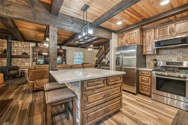 a kitchen with stainless steel appliances granite countertop a stove a sink dishwasher and cabinets with wooden floor