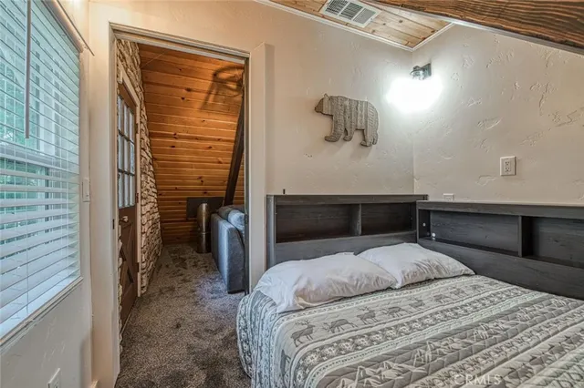 a bedroom with a bed a mirror and window