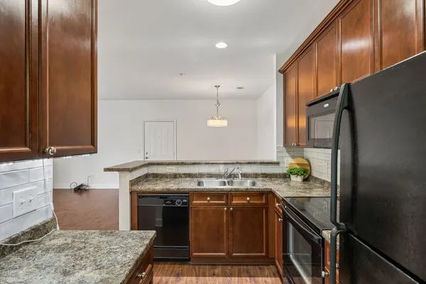 a kitchen with stainless steel appliances granite countertop a stove a sink and a refrigerator