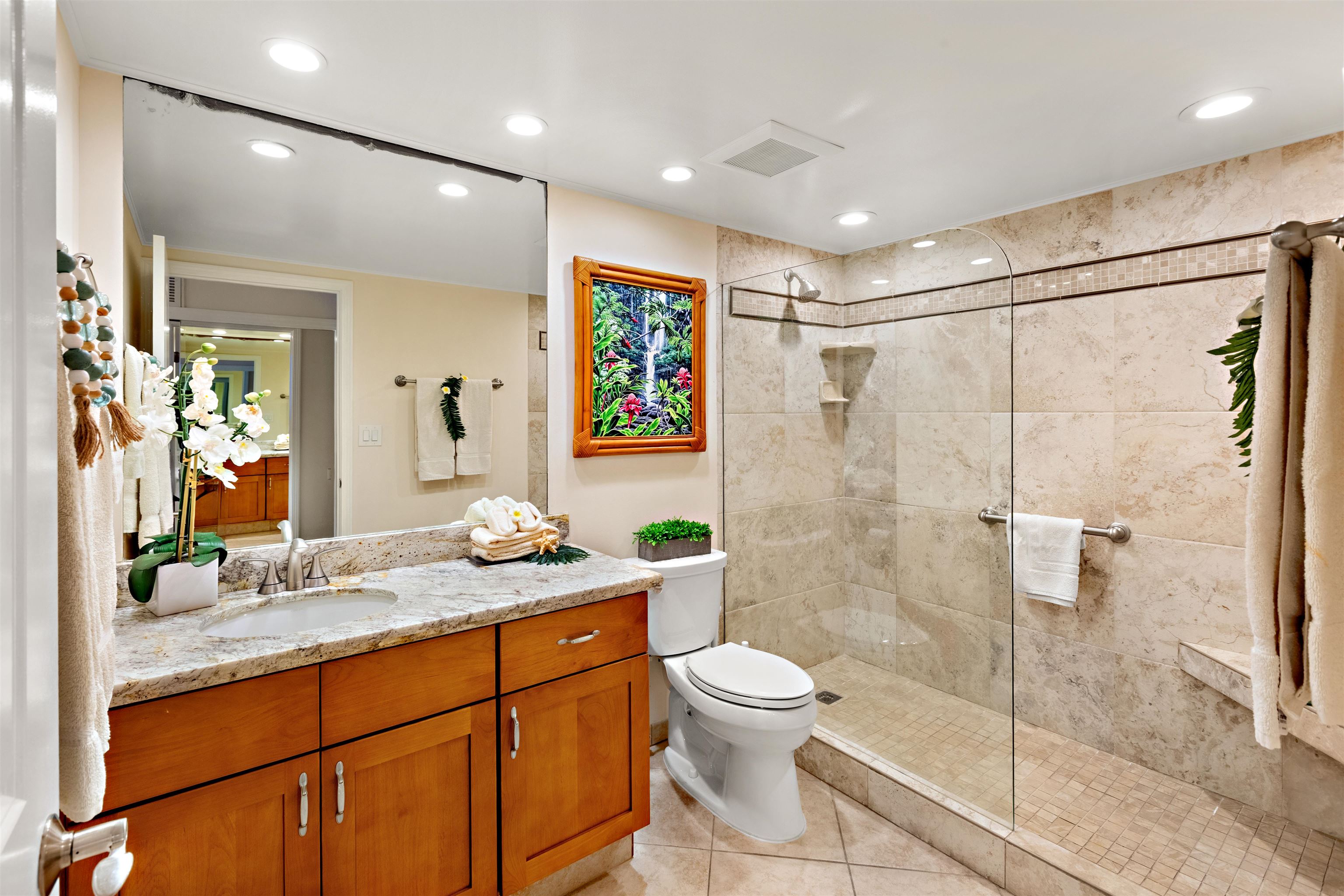 475 Front Street, Unit 430 Lahaina, HI 96761 - Photo 18 of 19 a bathroom with a granite countertop sink a toilet a mirror and shower