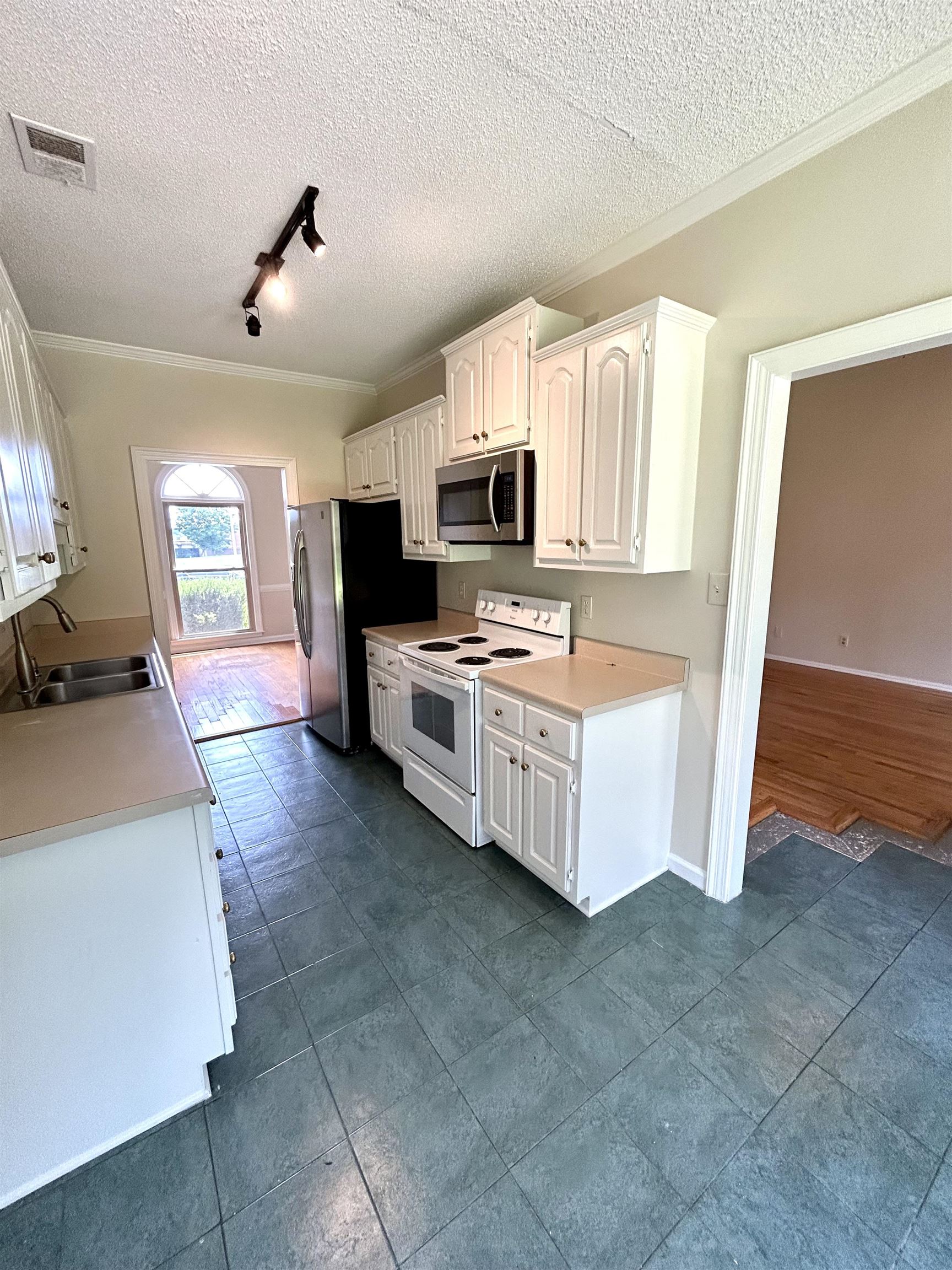 8528 Trinity Road Memphis, TN 38018 - Photo 7 of 21 a kitchen with stainless steel appliances a stove top oven a sink a counter top space and cabinets