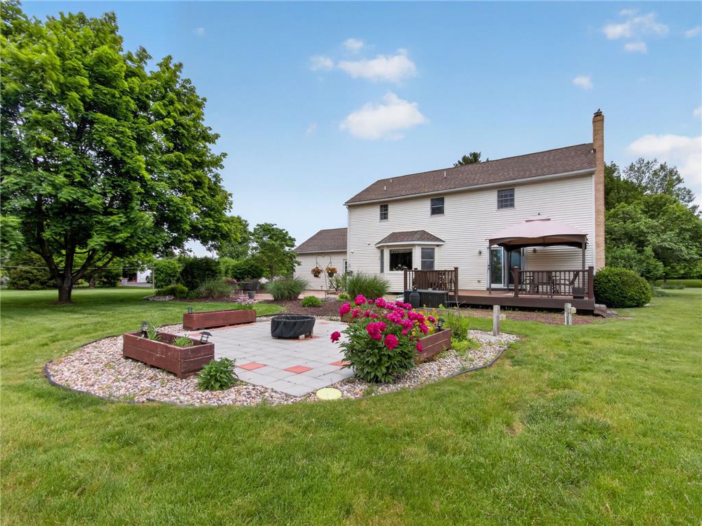 853 Lahr Road Nazareth, PA 18064 - Photo 23 of 29 A spacious backyard with mature trees, a deck, and a paver patio with a fire pit, perfect for outdoor enjoyment.