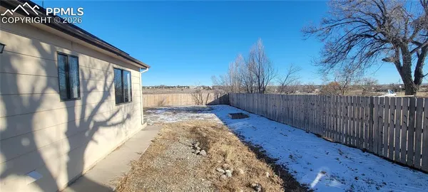a view of a backyard with wooden fence