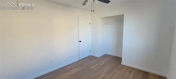 a view of an empty room with wooden floor