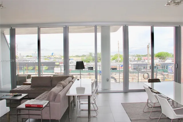 a living room with furniture and large windows