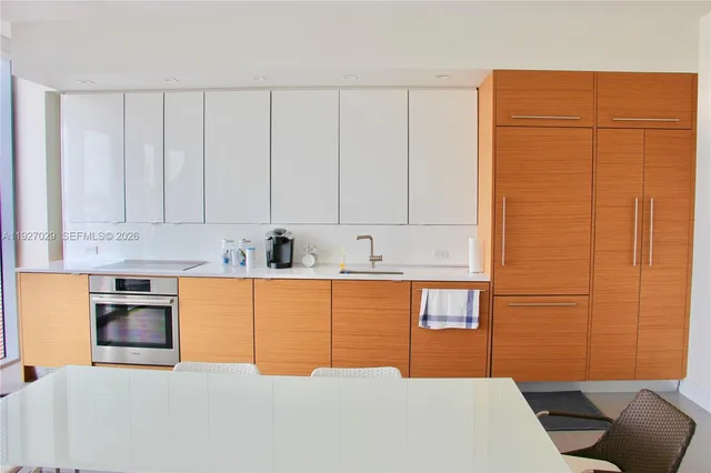 a kitchen with stainless steel appliances granite countertop a refrigerator a stove top oven a sink with granite countertops and cabinets