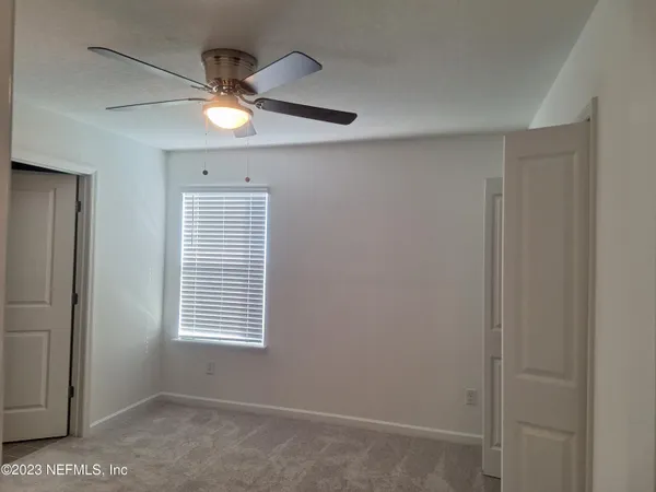 a view of a livingroom with a ceiling fan and window