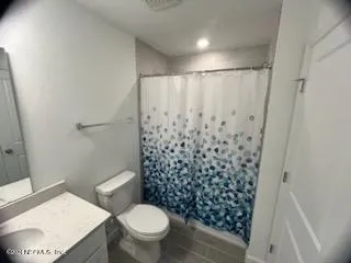 a white toilet sitting next to a shower curtain