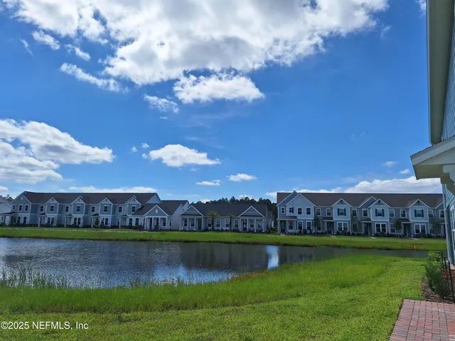 a view of building with garden and lake in the background