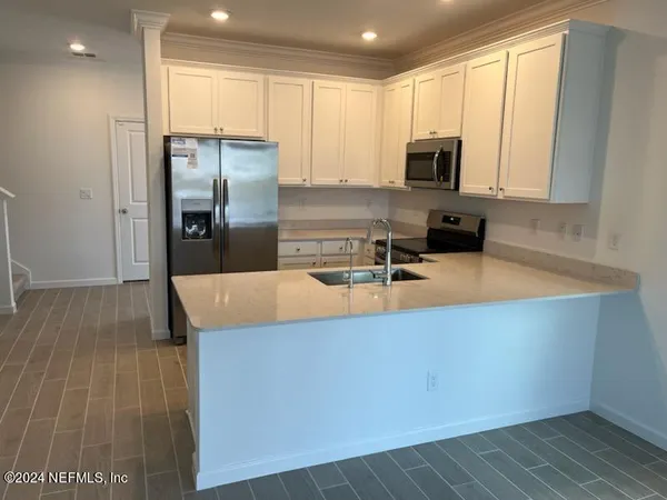 a kitchen with stainless steel appliances a refrigerator a stove a microwave and cabinets