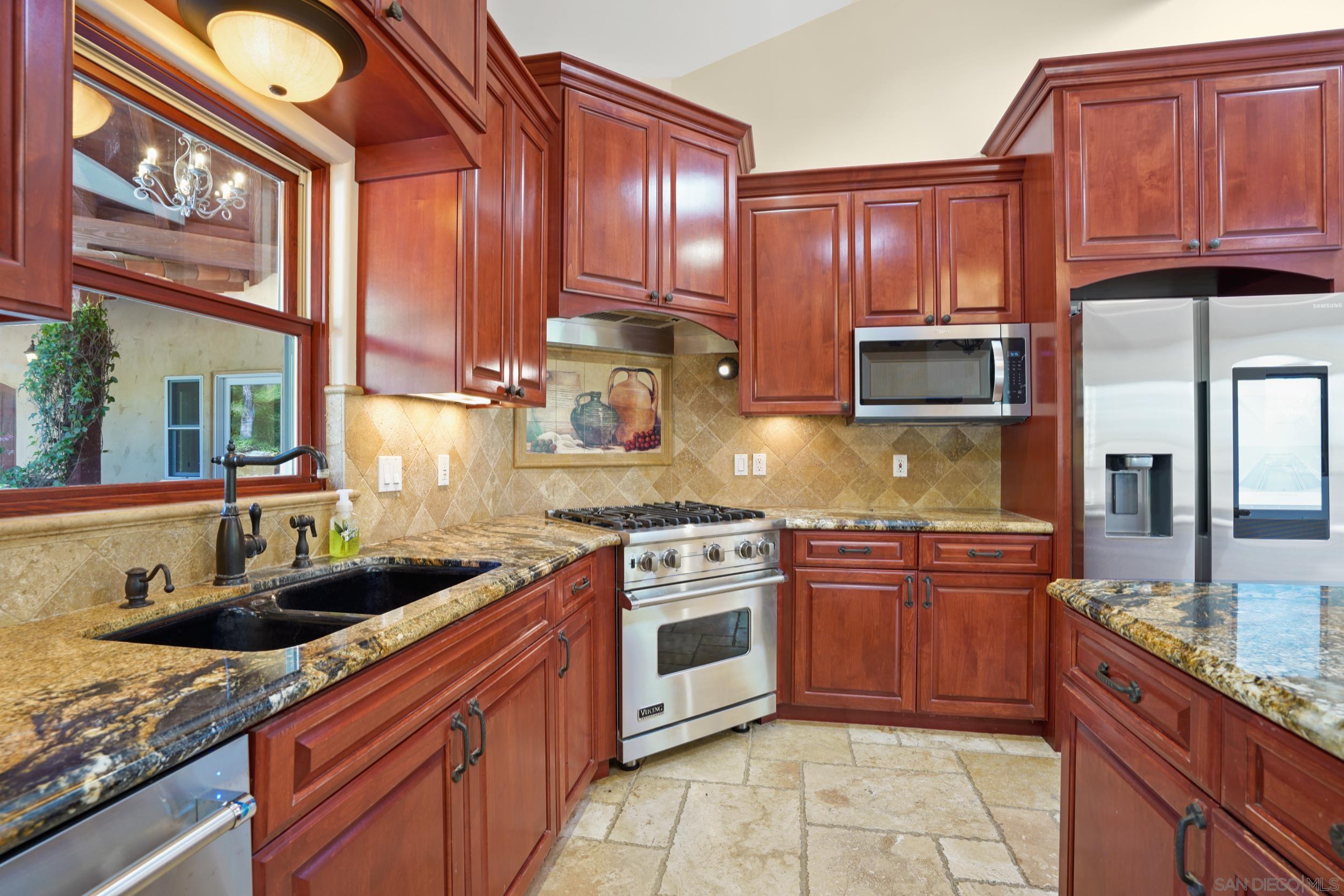 5352 Camino Jasmine Bonsall, CA 92003 - Photo 11 of 68 a kitchen with stainless steel appliances granite countertop wooden cabinets a stove a sink and dishwasher