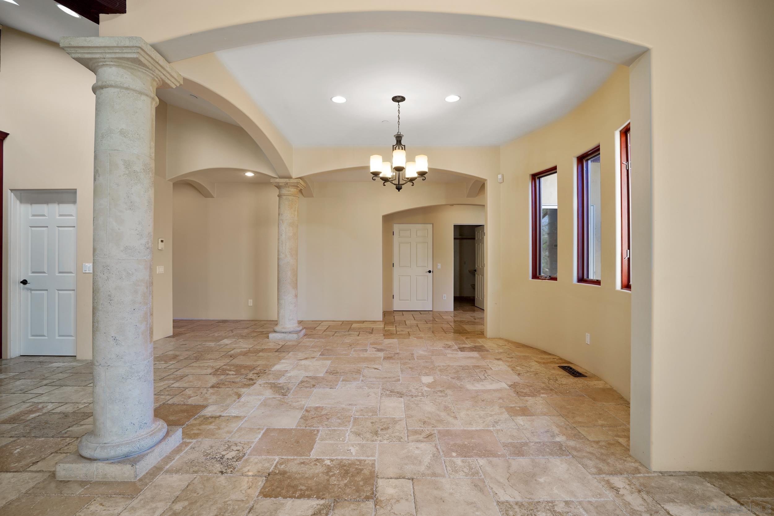 5352 Camino Jasmine Bonsall, CA 92003 - Photo 49 of 68 a view of a hallway with a chandelier fan and windows