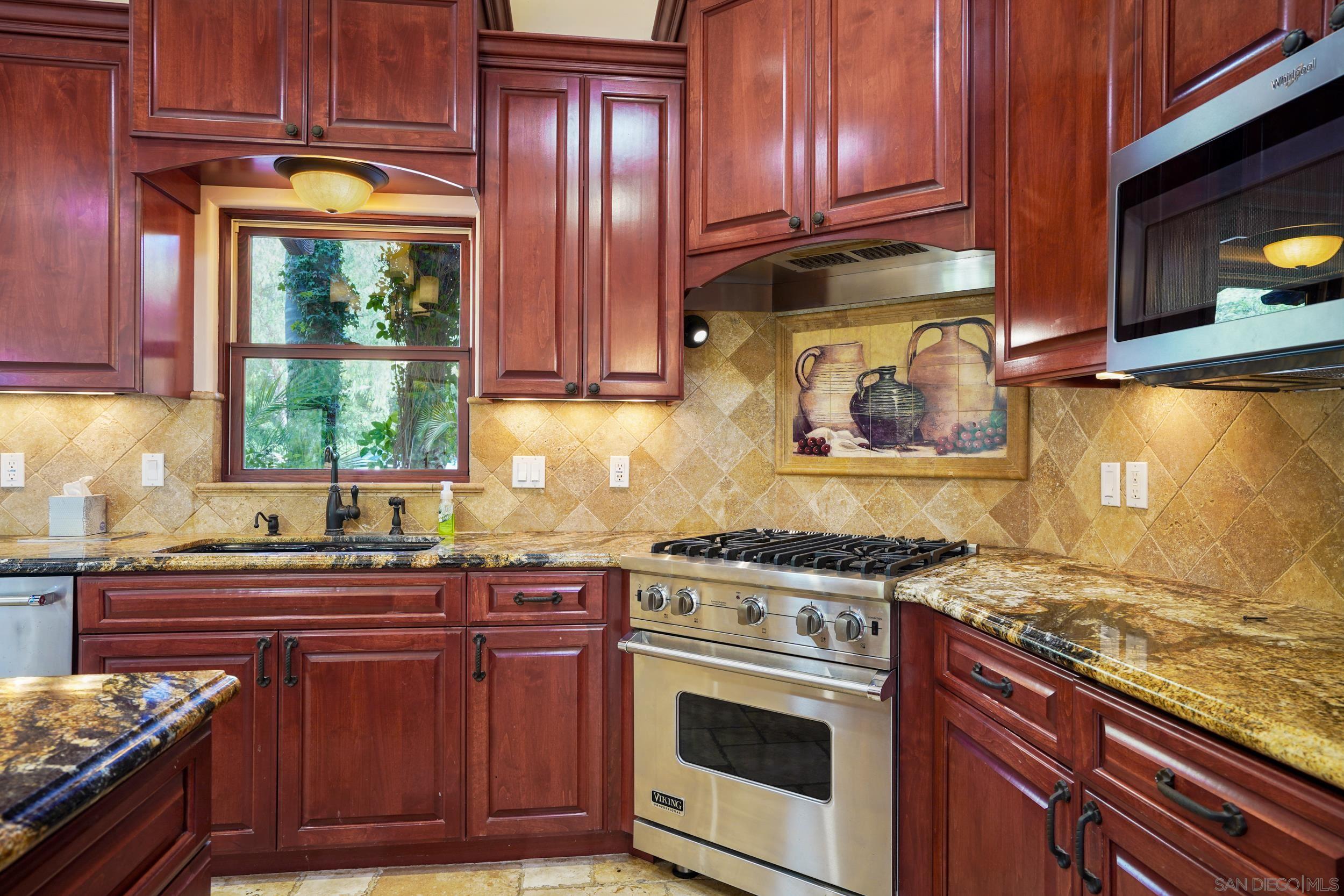 5352 Camino Jasmine Bonsall, CA 92003 - Photo 10 of 68 a kitchen with granite countertop wooden cabinets and a stove top oven