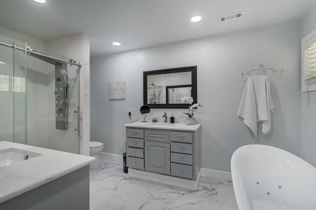 a bathroom with a tub sink and mirror