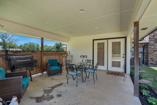 a view of a patio with table and chairs potted plants with wooden fence