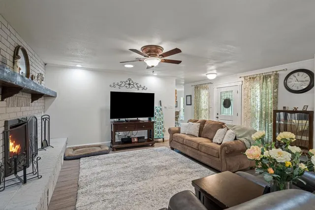 a living room with furniture a fireplace and a flat screen tv