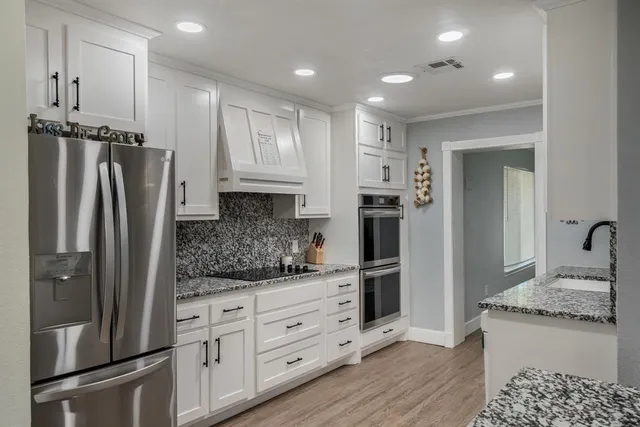 a kitchen with stainless steel appliances granite countertop a refrigerator and a stove