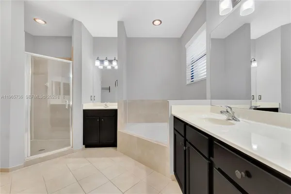 a spacious bathroom with a bathtub sink and mirror