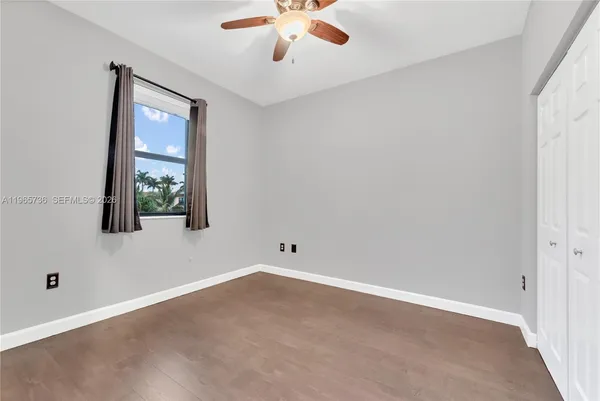 an empty room with a window and a ceiling fan