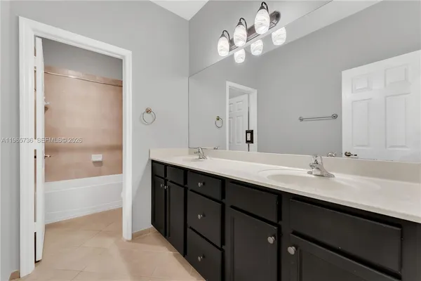 a bathroom with a sink double vanity granite tub and a mirror