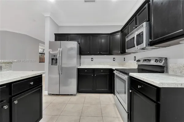 a kitchen with stainless steel appliances granite countertop a stove a refrigerator and a sink