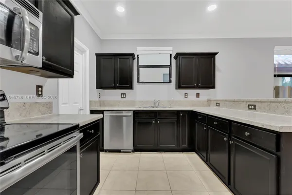 a kitchen with stainless steel appliances kitchen island granite countertop a sink and a stove