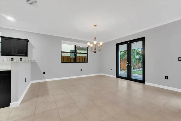 a view of a livingroom with a chandelier fan and windows