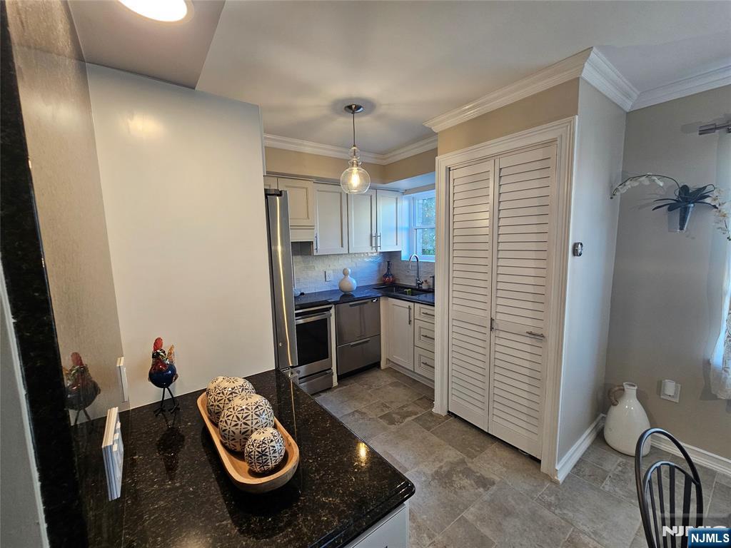 63-69 Rome Street Newark, NJ 07105 - Photo 8 of 14 a kitchen with sink refrigerator dining table and chairs