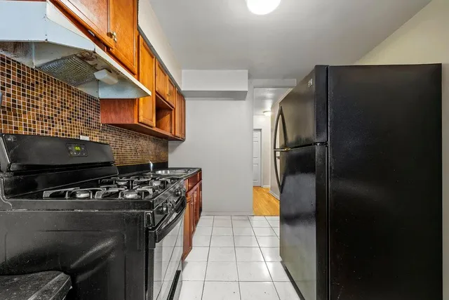 a kitchen with stainless steel appliances granite countertop a refrigerator and a stove top oven