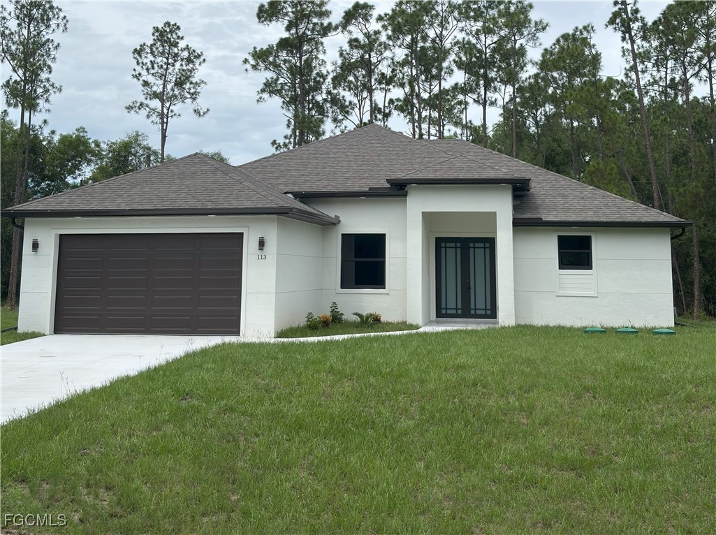 113 Monroe Avenue Lehigh Acres, FL 33936 - Photo 1 of 24 a front view of a house with a yard and garage