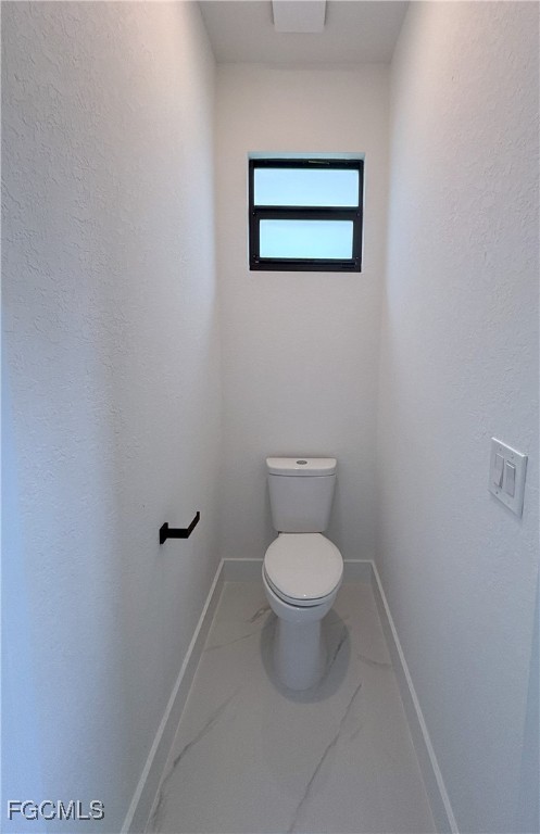 113 Monroe Avenue Lehigh Acres, FL 33936 - Photo 16 of 24 a white toilet sitting next to a white wall