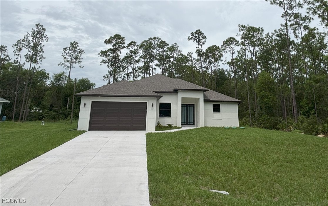 113 Monroe Avenue Lehigh Acres, FL 33936 - Photo 2 of 24 a front view of a house with yard