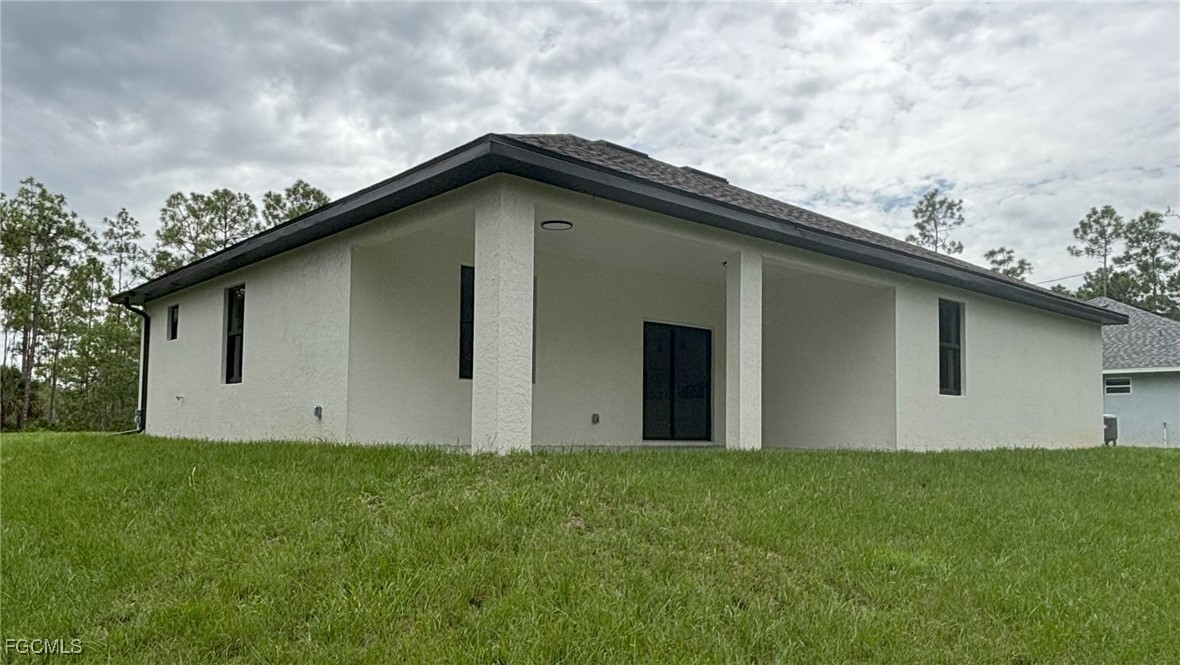 113 Monroe Avenue Lehigh Acres, FL 33936 - Photo 23 of 24 a house with garden in front of it