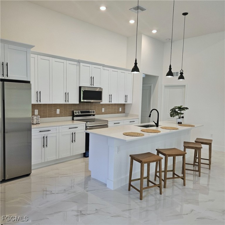 113 Monroe Avenue Lehigh Acres, FL 33936 - Photo 3 of 24 a kitchen with a sink stainless steel appliances and white cabinets