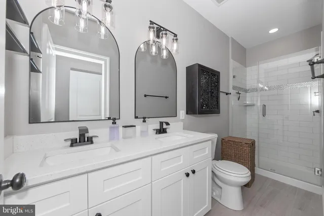a bathroom with a double vanity sink toilet and mirror