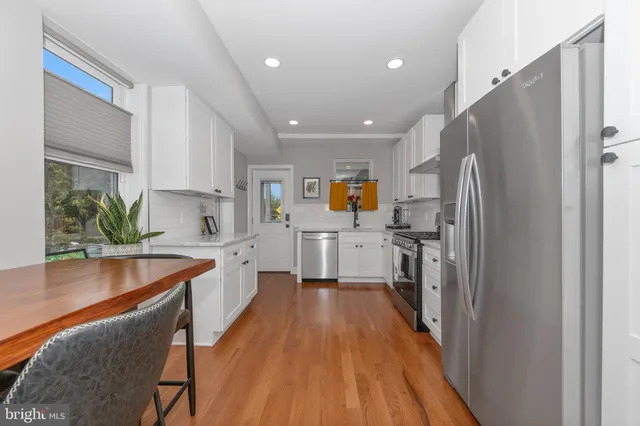 a kitchen with stainless steel appliances a refrigerator sink and wooden cabinets