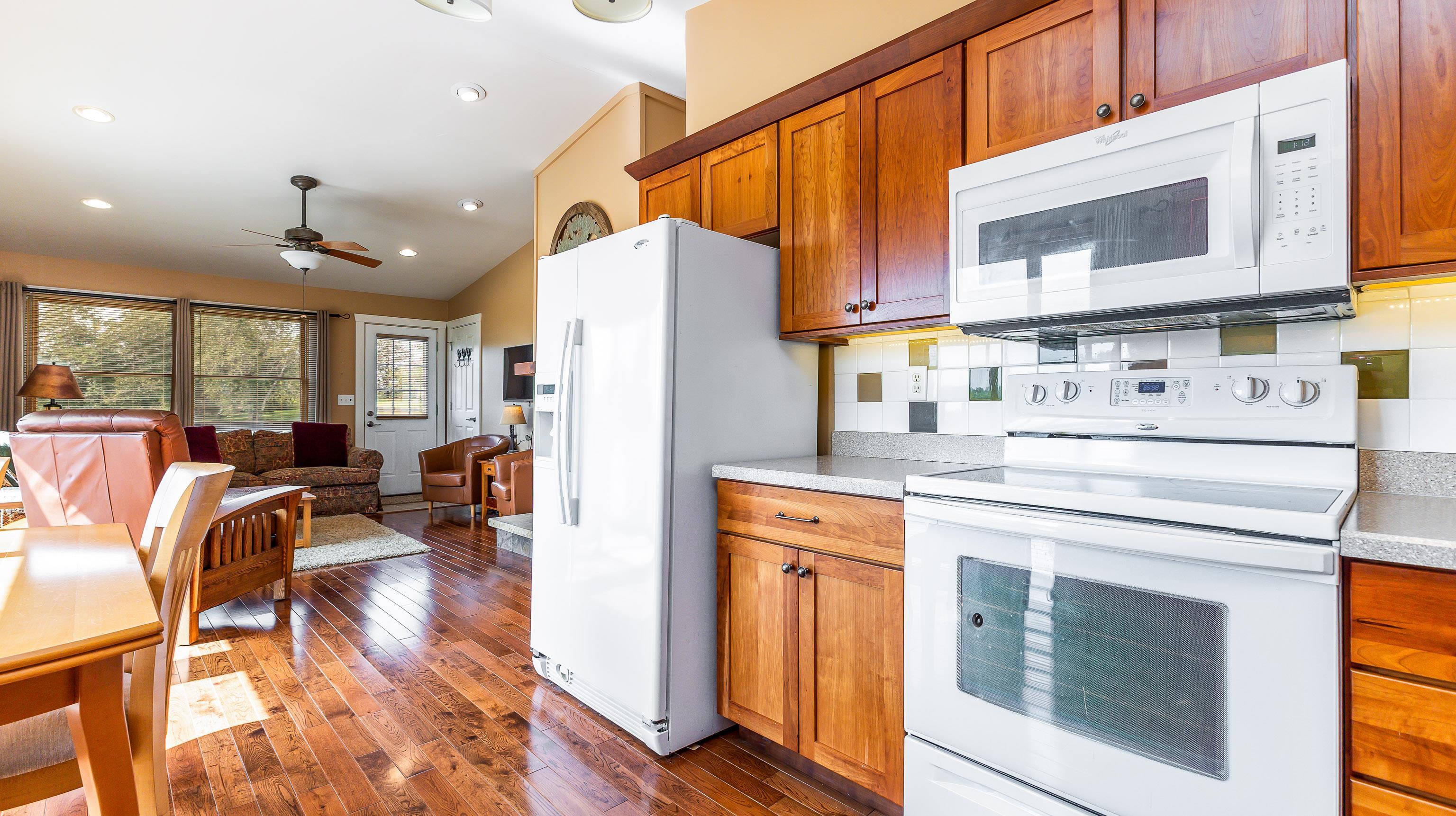 2 Sunbow Path Galena, IL 61036 - Photo 11 of 37 a kitchen with stainless steel appliances a stove a refrigerator a sink and white cabinets with wooden floors
