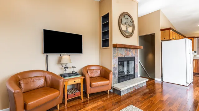 a living room with furniture a flat screen tv and a fireplace
