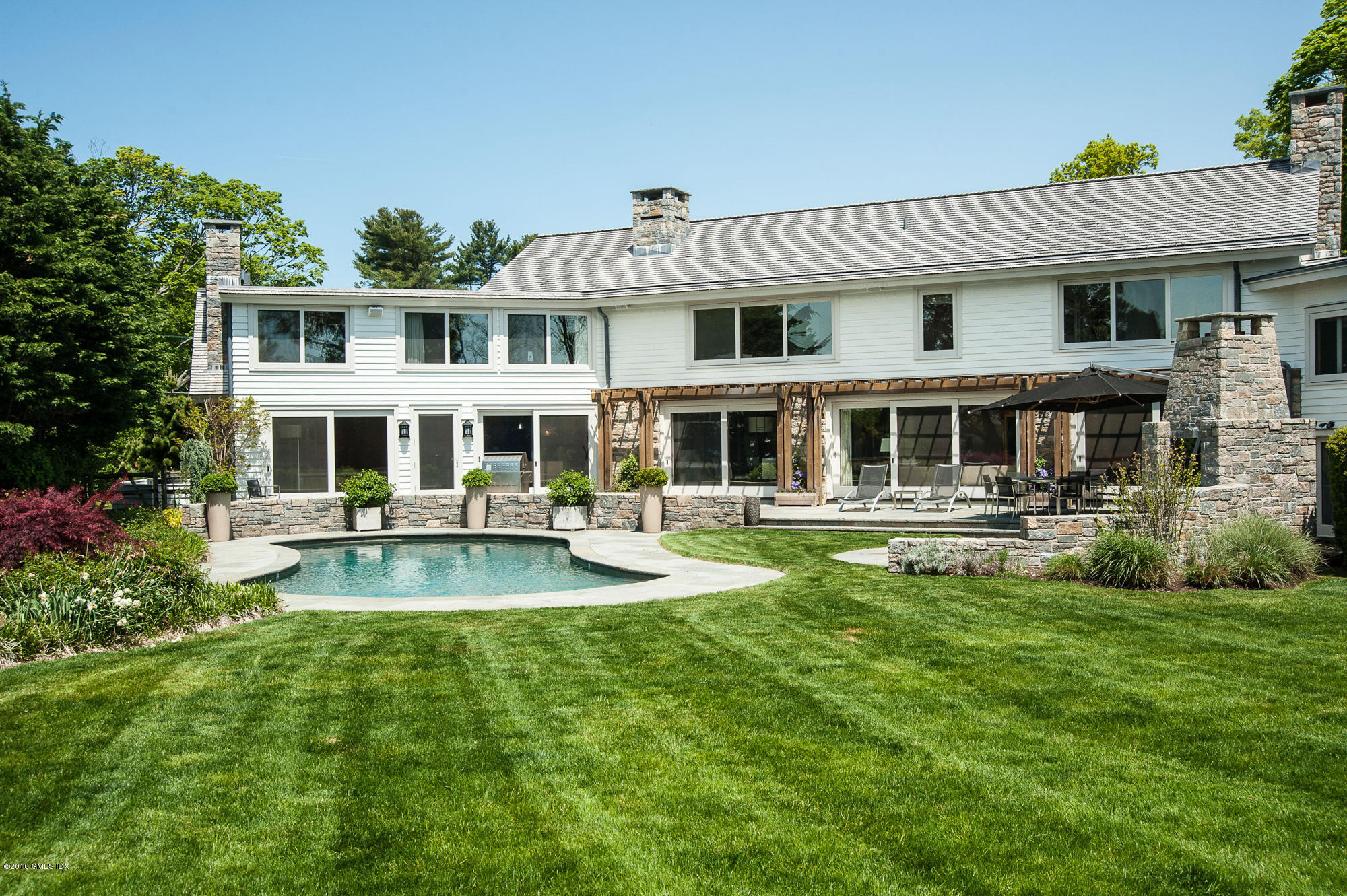 2 Seagate Road Riverside, CT 06878 - Photo 26 of 38 a front view of a residential apartment building with a yard table and chairs