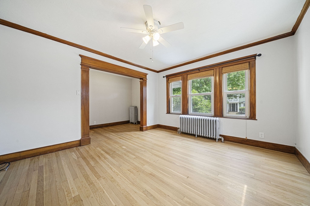 104 Greaton Road, Unit 1 Boston, MA 02132 - Photo 2 of 29 a view of an empty room with wooden floor and a window