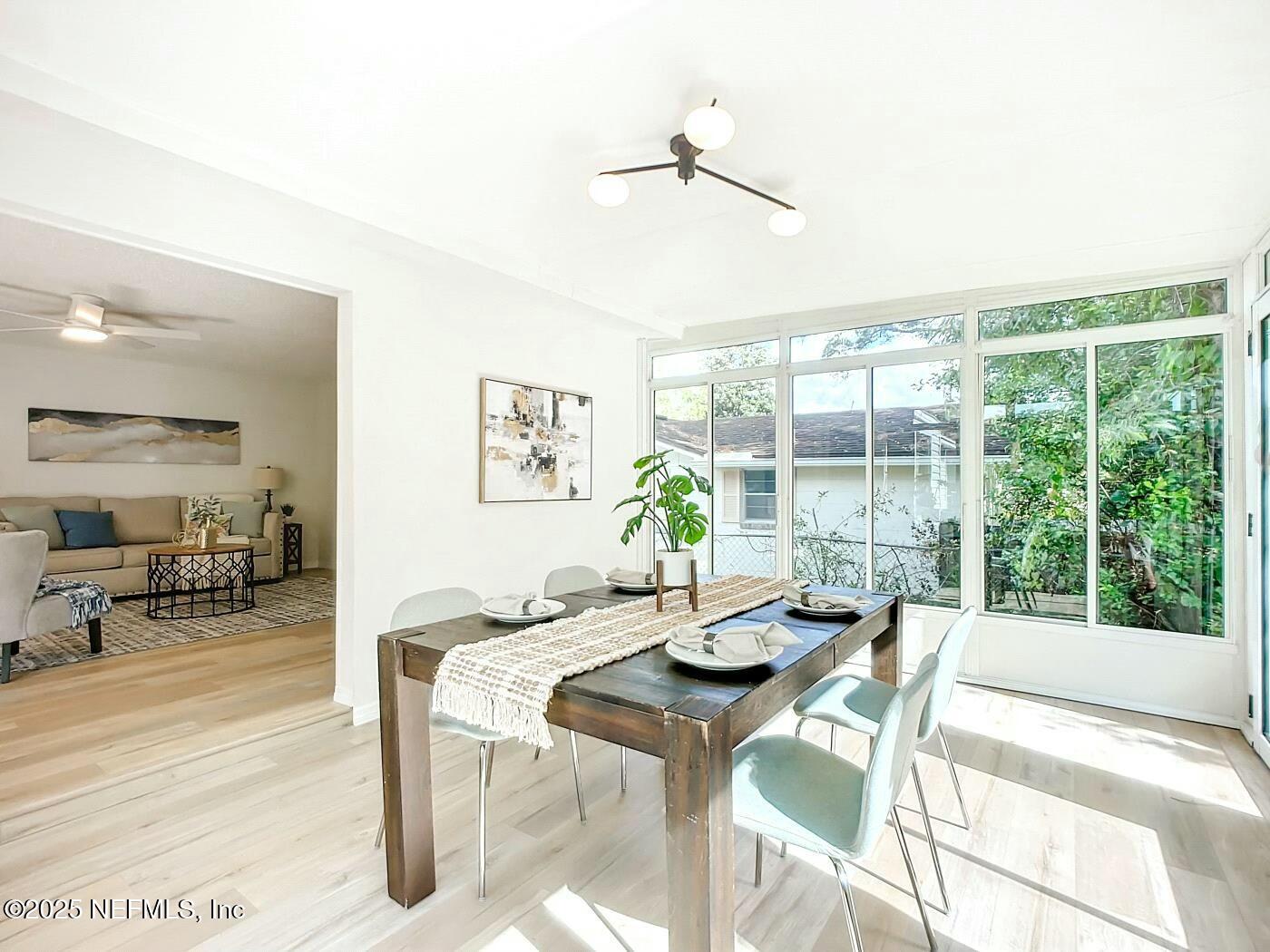 8735 Moss Haven Road Jacksonville, FL 32221 - Photo 16 of 29 a view of a dining room with furniture large windows and wooden floor