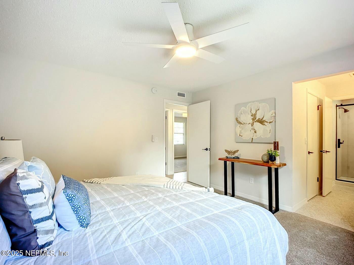 8735 Moss Haven Road Jacksonville, FL 32221 - Photo 18 of 29 a bedroom with a bed and a chandelier