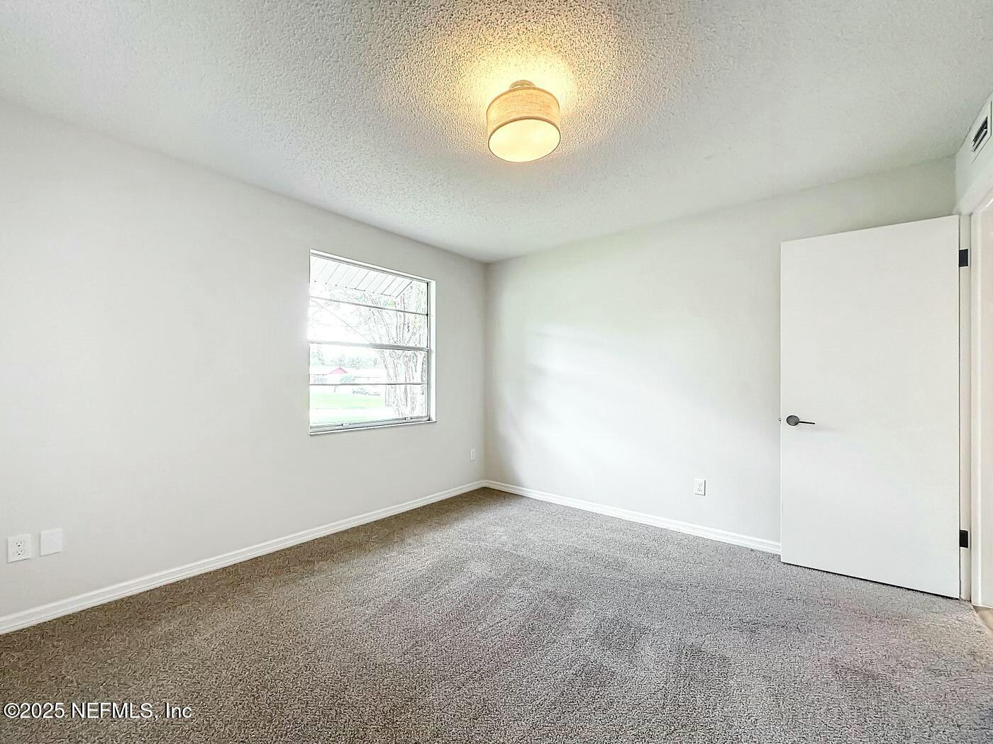 8735 Moss Haven Road Jacksonville, FL 32221 - Photo 20 of 29 an empty room with a window and a fan