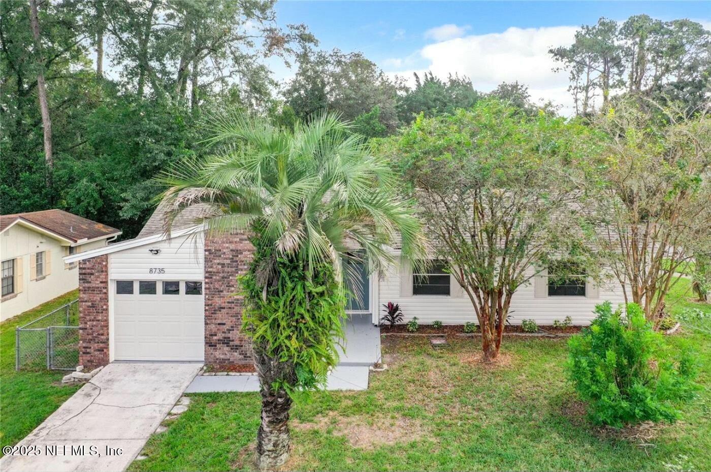 8735 Moss Haven Road Jacksonville, FL 32221 - Photo 29 of 29 a front view of a house with a yard and trees