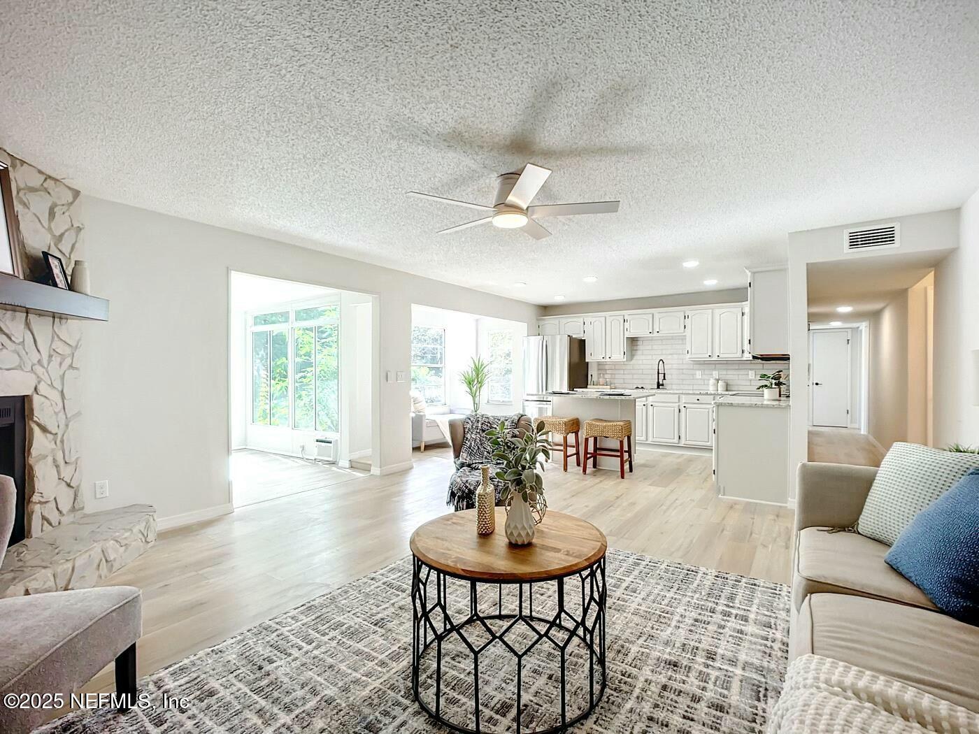 8735 Moss Haven Road Jacksonville, FL 32221 - Photo 9 of 29 a living room with furniture a fireplace and a table with wooden floor