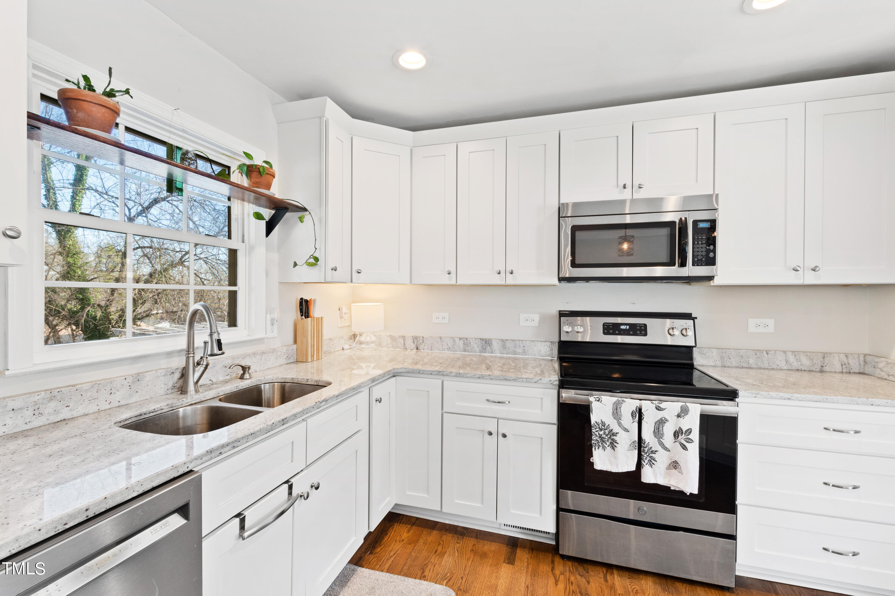 2413 Kennington Road Raleigh, NC 27610 - Photo 14 of 33 a kitchen with stainless steel appliances granite countertop a sink a stove a microwave and cabinets