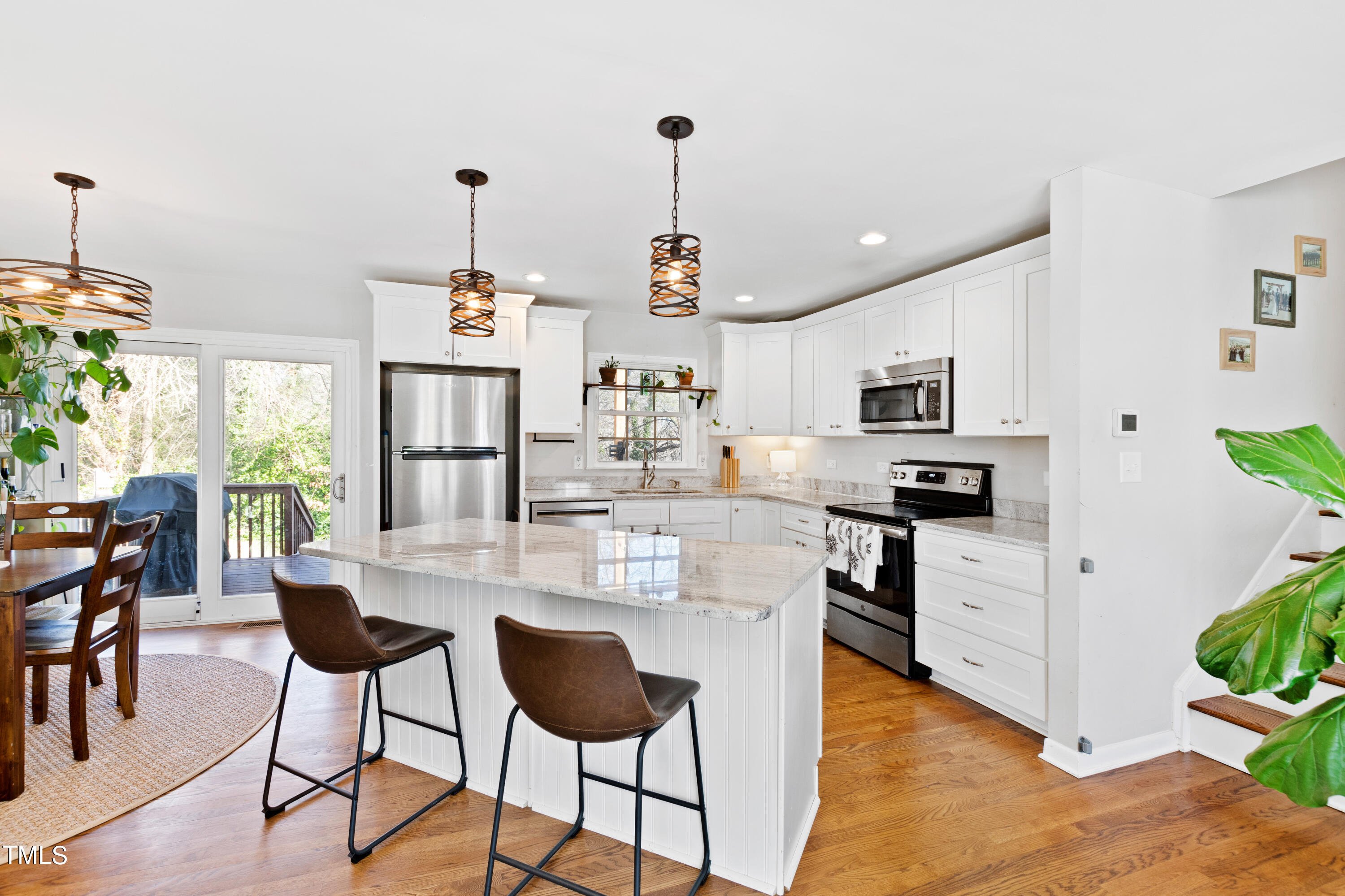 2413 Kennington Road Raleigh, NC 27610 - Photo 2 of 33 a kitchen with stainless steel appliances kitchen island granite countertop a dining table chairs and white cabinets