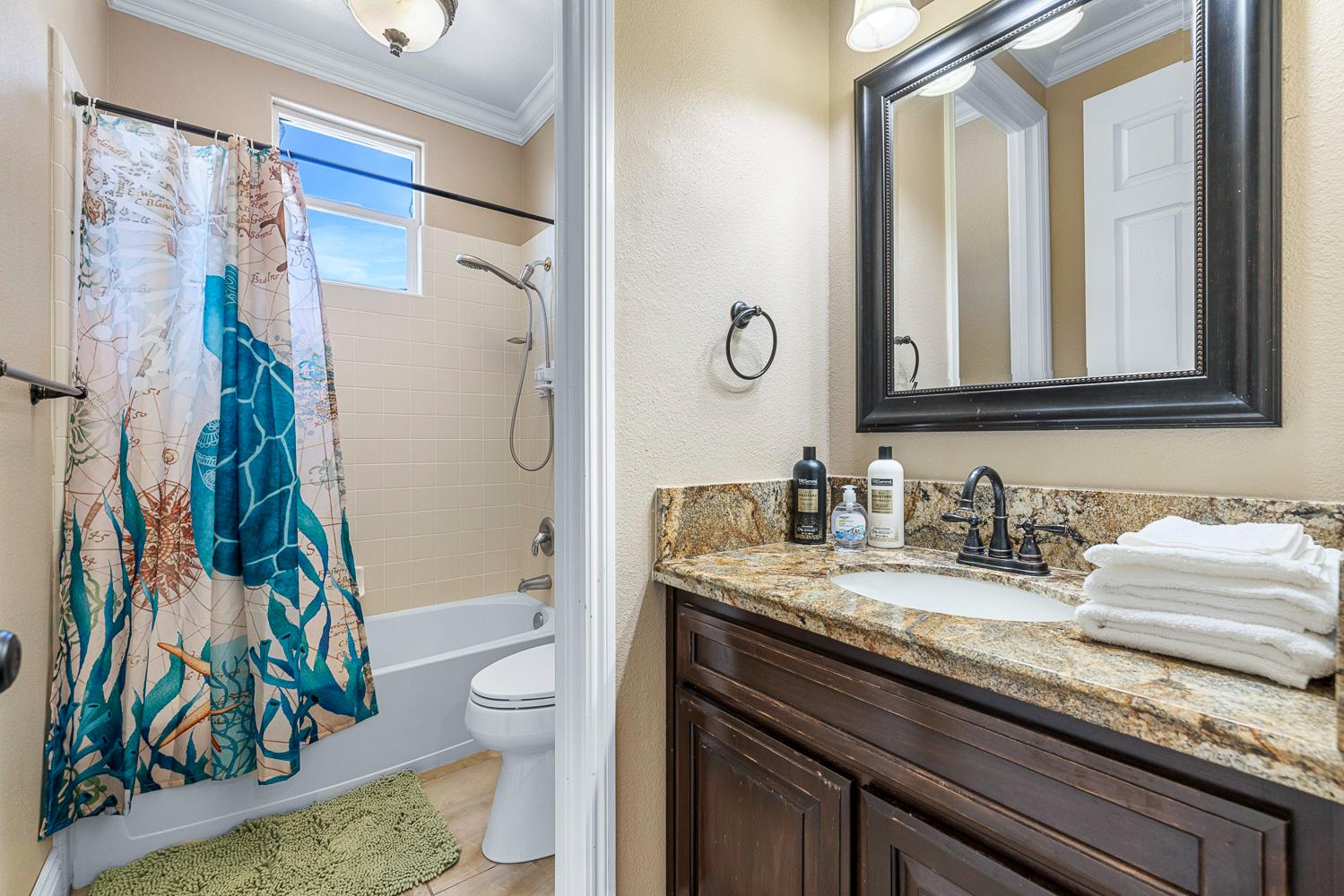 3133 Everglade Avenue Clovis, CA 93619 - Photo 18 of 33 a bathroom with a granite countertop sink a toilet and a shower curtain