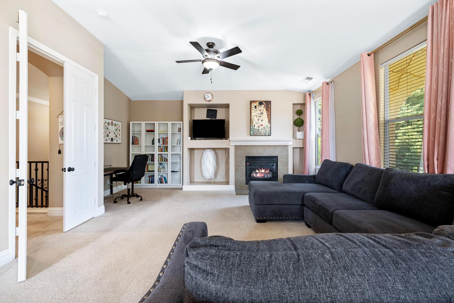 3133 Everglade Avenue Clovis, CA 93619 - Photo 21 of 33 a living room with furniture a fireplace and a flat screen tv