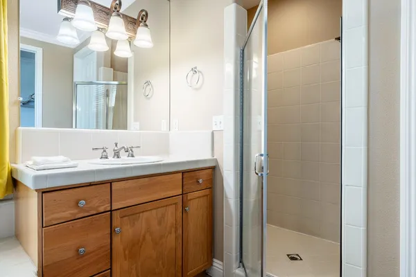 a bathroom with a granite countertop sink a mirror and a shower